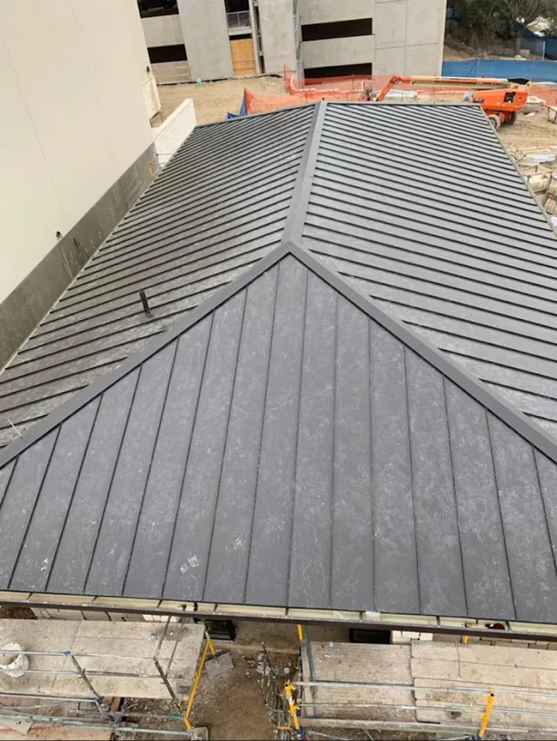 Commercial metal roof construction with crane equipment in Monroe